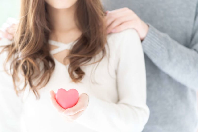 ピンクのハートを手にする女性